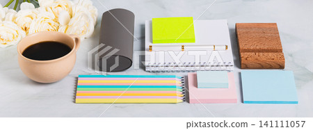 A notebook, pen, cup of coffee and stationery on a desk web banner A notebook, pen, cup of coffee and stationery on a desk web banner 141111057