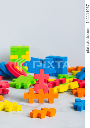 Colorful puzzle pieces for children's tabletop game vertical view Colorful puzzle pieces for children's tabletop game vertical view 141111087