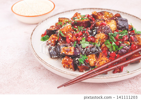 fried eggplant, Chinese style, in sweet and sour sauce, with pepper and sesame seeds. on a white plate, fried eggplant, Chinese style, in sweet and sour sauce, with pepper and sesame seeds. on a white plate, 141111203