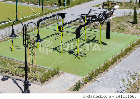 outdoor workout gym with modern fitness equipment on a green safety rubber surface in public park in Bansko, Bulgaria 141111663