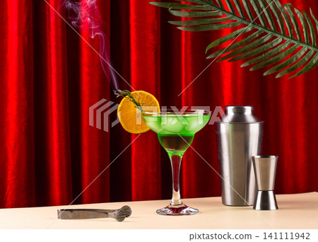 Retro green cocktail against a red curtain Retro green cocktail against a red curtain 141111942