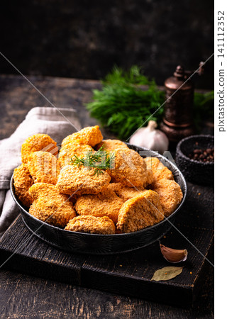 Raw uncooked frozen chicken nuggets Raw uncooked frozen chicken nuggets 141112352
