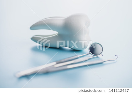 Dental Tools and Tooth Model on Blue Background for Oral Care and Dental Clinic Use Dental Tools and Tooth Model on Blue Background for Oral Care and Dental Clinic Use 141112427