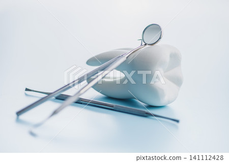 Dental Tools and Tooth Model on Blue Background for Oral Care and Dental Clinic Use Dental Tools and Tooth Model on Blue Background for Oral Care and Dental Clinic Use 141112428