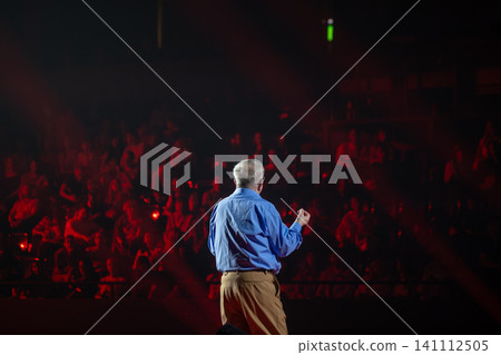 Public speaking at a leadership conference, keynote speaker addressing an engaged audience from stage 141112505