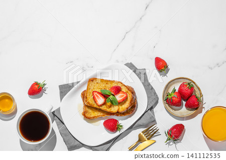 Brioche toasts with strawberry and honey on a plate on a marble background Brioche toasts with strawberry and honey on a plate on a marble background 141112535
