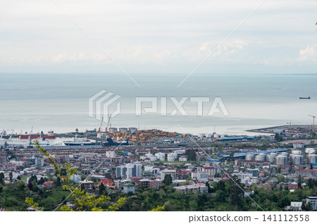 City port and coastal industrial landscape with calm sea horizon. 141112558
