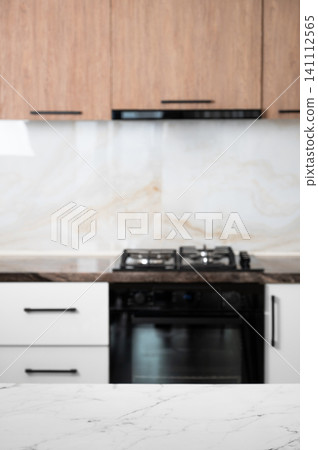 A bright kitchen with a stove and stone countertop in a minimalist style A bright kitchen with a stove and stone countertop in a minimalist style 141112565