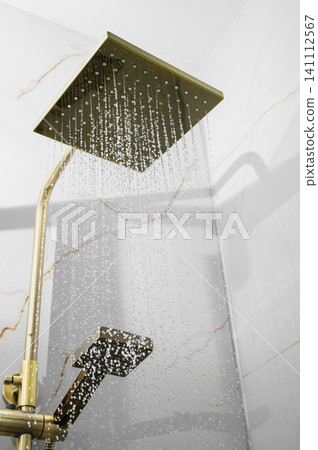Luxury rainfall shower head with running water in modern bathroom interior Luxury rainfall shower head with running water in modern bathroom interior 141112567