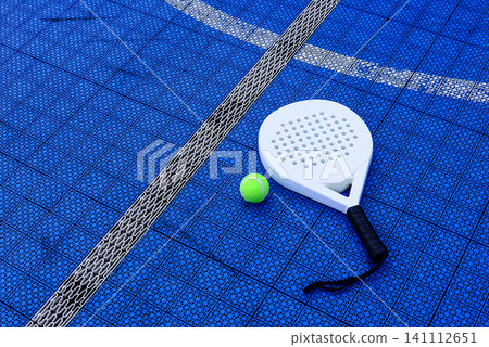 A padel racket and ball. on blue court A padel racket and ball. on blue court 141112651