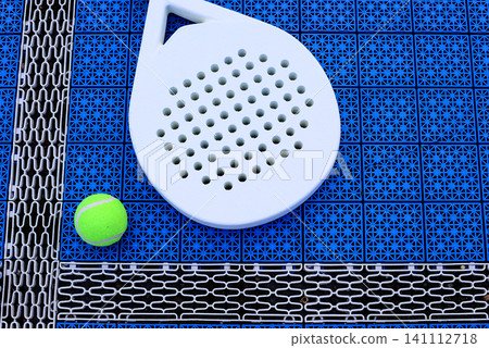 A padel racket and ball. on blue court A padel racket and ball. on blue court 141112718