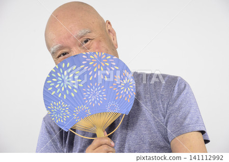 一位微笑的老人拿著扇子 一位微笑的老人拿著扇子 141112992