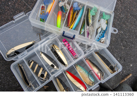 An overhead photo of a transparent storage box used to organize fishing lures. An overhead photo of a transparent storage box used to organize fishing lures. 141113360
