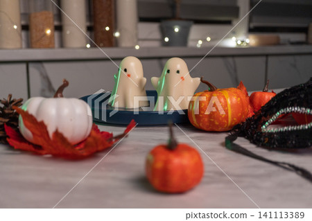 Halloween ghost desserts with decorative pumpkins and festive autumn decor on marble table Halloween ghost desserts with decorative pumpkins and festive autumn decor on marble table 141113389