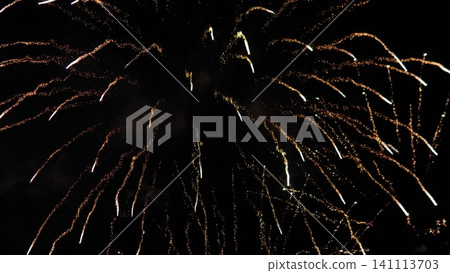 Golden fireworks burst across dark night sky with bright spark trails, curved light arcs, glowing embers, dramatic contrast, festive atmosphere, abstract celebration backdrop Golden fireworks burst across dark night sky with bright spark trails, curved light arcs, glowing embers, dramatic contrast, festive atmosphere, abstract celebration backdrop 141113703