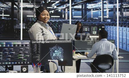 Joyous data center technician working with AI visualization insights to improve system health. Joyous data center technician working with AI visualization insights to improve system health. 141113752