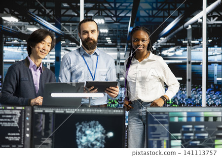 Multiethnic server room IT team running AI prediction simulations, tracking performance. Multiethnic server room IT team running AI prediction simulations, tracking performance. 141113757