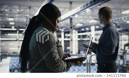 Data center administrator uses a laptop to monitor deep learning processes, working with AI technology and high performance systems. Data center administrator uses a laptop to monitor deep learning processes, working with AI technology and high performance systems. 141113760