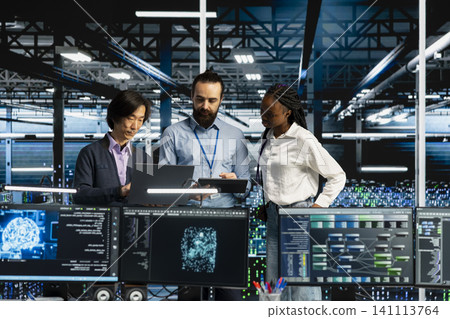 Team of server room coworkers in office running AI prediction simulations, tracking performance. Team of server room coworkers in office running AI prediction simulations, tracking performance. 141113764