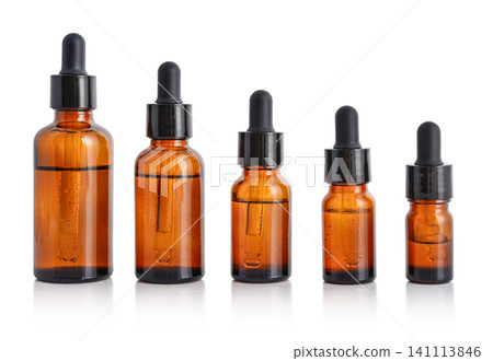 Five amber glass dropper bottles of different sizes isolated on white background with clipping path. Five amber glass dropper bottles of different sizes isolated on white background with clipping path. 141113846