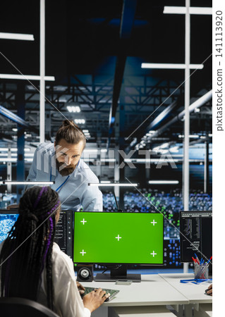 Server room manager overseeing engineer working with isolated screen computer to run AI prediction simulations. Server room manager overseeing engineer working with isolated screen computer to run AI prediction simulations. 141113920