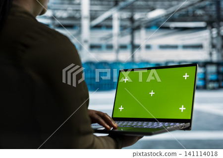 Data center programmer works with a chroma key laptop, using an editable screen to expand workload capacity. Data center programmer works with a chroma key laptop, using an editable screen to expand workload capacity. 141114018
