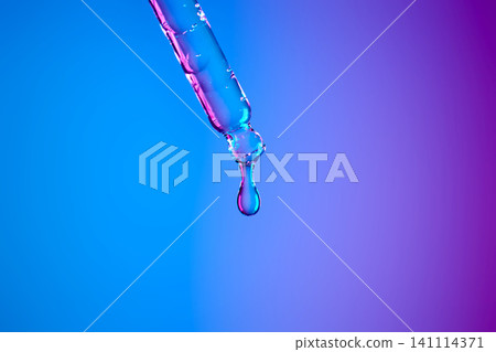 Dropper dispensing liquid serum against neon blue and purple background Dropper dispensing liquid serum against neon blue and purple background 141114371