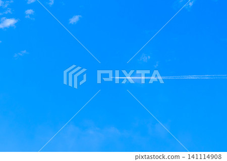 An airplane flying straight across the blue sky and a white contrail. 141114908