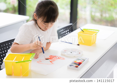 一位小學年齡層的小女孩在美術課上畫水彩畫;培養創意;概述學校和課外活動。 一位小學年齡層的小女孩在美術課上畫水彩畫;培養創意;概述學校和課外活動。 141115017