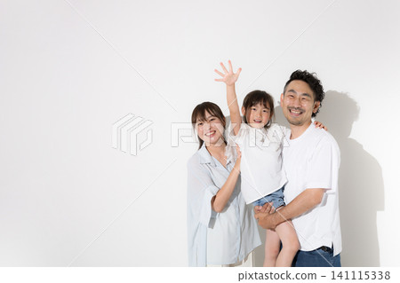 A happy family with smiling faces against a white background – a glimpse of a family's joyful life, wearing short sleeves, and waving goodbye to the camera in a summer vacation image. A happy family with smiling faces against a white background – a glimpse of a family's joyful life, wearing short sleeves, and waving goodbye to the camera in a summer vacation image. 141115338