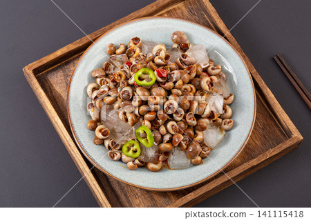 iced sea snails served with fresh green chili peppers on white background, refreshing summer seafood delicacy. iced sea snails served with fresh green chili peppers on white background, refreshing summer seafood delicacy. 141115418