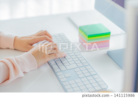 Young woman's hand operating a personal computer Young woman's hand operating a personal computer 141115986