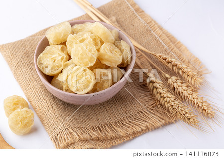 dried Chinese wheat gluten noodles in a ceramic bowl with wheat stalks, raw ingredients for traditional Asian cuisine dried Chinese wheat gluten noodles in a ceramic bowl with wheat stalks, raw ingredients for traditional Asian cuisine 141116073