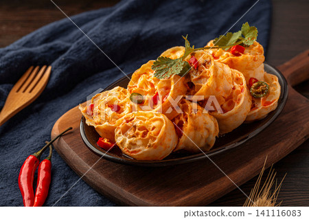 spicy cold wheat gluten noodles served on a black plate with red chili peppers, spicy cold wheat gluten noodles served on a black plate with red chili peppers, 141116083