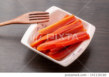marinated pickled carrot strips served in a square ceramic dish with a wooden fork, traditional appetizer marinated pickled carrot strips served in a square ceramic dish with a wooden fork, traditional appetizer 141116180
