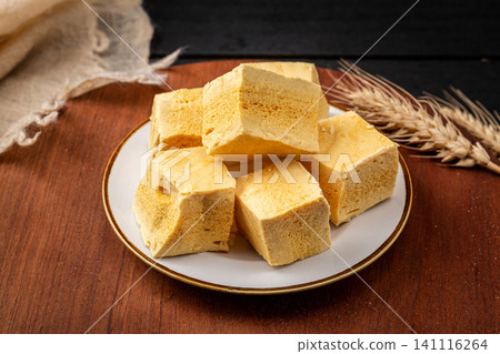 Bite sized pieces of handmade honeycomb sponge candy on a grey plate Bite sized pieces of handmade honeycomb sponge candy on a grey plate 141116264