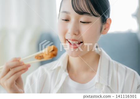 一位年輕女子正在吃炸雞 141116301
