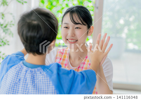 幼兒園老師和孩子們在玩手部遊戲。 141116348