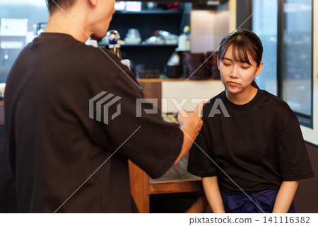 Female staff member gets lectured at izakaya (Japanese pub) Female staff member gets lectured at izakaya (Japanese pub) 141116382