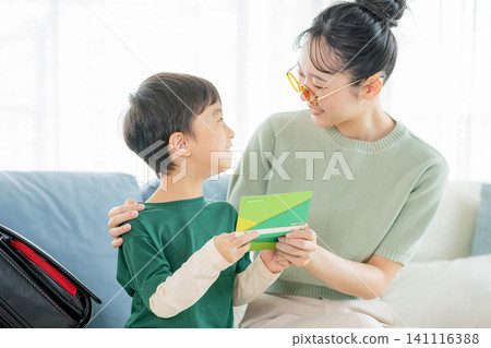 Parent and child looking at bankbook 141116388