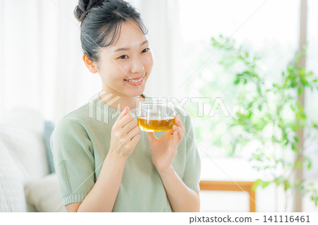 一個喝茶的年輕女子 141116461