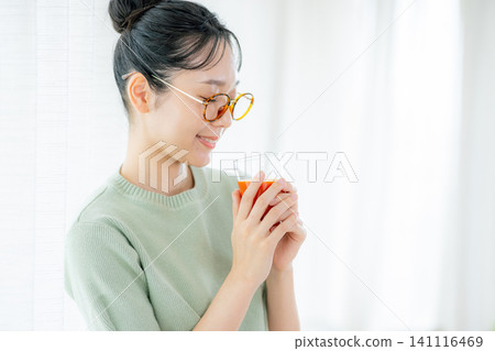 一位年輕女子正在喝番茄汁 141116469