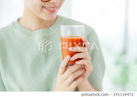 一位年輕女子正在喝番茄汁 141116472