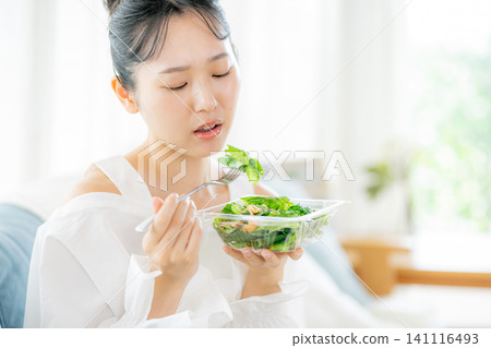 A young woman eating a salad A young woman eating a salad 141116493