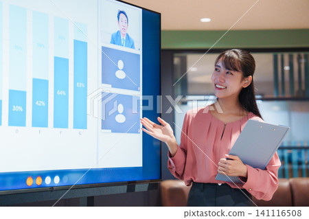 A woman giving a presentation while connecting with remote members. 141116508