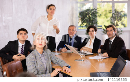 Woman and man sitting at table beside during meeting in conference room 141116863