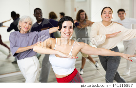 Young Hispanic woman learning dynamic dances in choreography class Young Hispanic woman learning dynamic dances in choreography class 141116897