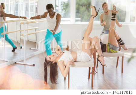 Women in heels dance while lying on chair 141117015
