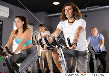 Sporty man working out on stationary bicycle in gym Sporty man working out on stationary bicycle in gym 141117079
