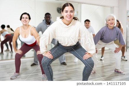 Group of dancing people practice synchronized choreography Group of dancing people practice synchronized choreography 141117105